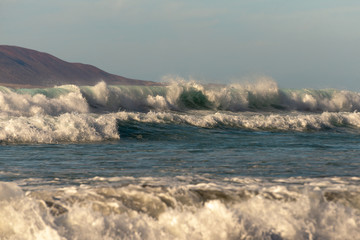 ocean beach break in the evening light and mountains