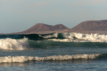 ocean beach break in the evening light and mountains