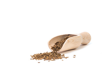 Cumin seeds isolated on white. Small cumin and wooden scoop on a white background. The concept of using herbs and spices for dishes. Improving the taste. Strong taste of dishes.
