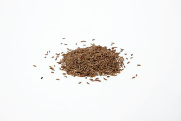 Cumin seeds isolated on white. Small cumin spilled on a white background. The concept of using herbs and spices for dishes. Strong taste of dishes. Improving the taste in dishes.