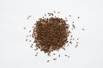 Cumin seeds isolated on white. Small cumin spilled on a white background. The concept of using herbs and spices for dishes. Strong taste of dishes. Improving the taste in dishes.