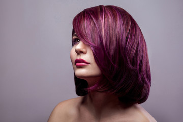 Portrait of beautiful fashion model woman with short purple colored hairstyle and makeup and...