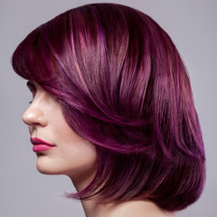 Profile side view portrait of beautiful fashion model woman with short purple colored hairstyle and...