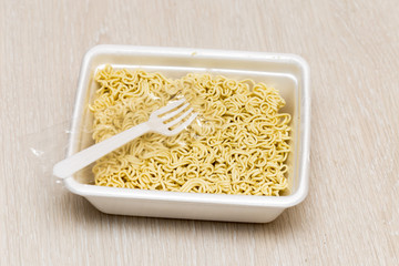 Raw food noodles quickly with a fork on the table