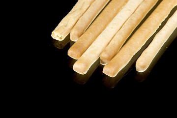 Delicious crispy pastry sticks isolated on black