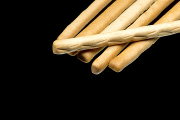 Delicious crispy pastry sticks isolated on black