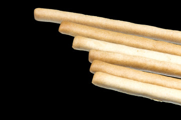 Delicious crispy pastry sticks isolated on black