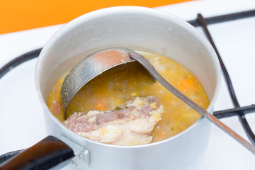 pea soup with meat on a gas stove