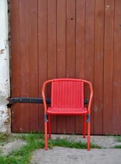 Fototapeta na wymiar Roter Stuhl vor Holzwand