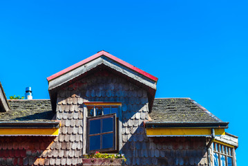 Fototapeta premium View of a wooden building against the blue sky, Puerto Varas, Chile. Isolated on blue background.