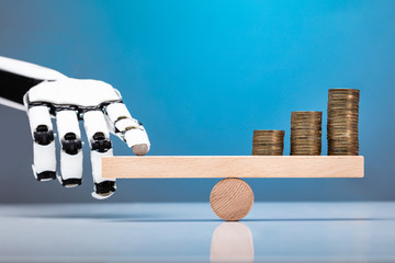 Robot Balancing Stacked Coins With Finger On Seesaw