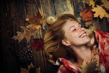 Sweet young woman playing with leaves and looks very sensually. Sensual woman wearing pullover, looking at camera. Attractive young woman wearing in fashionable seasonal clothes having Autumnal mood.