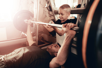 Fototapeta na wymiar Son Support To Father While Lifting The Barbell.