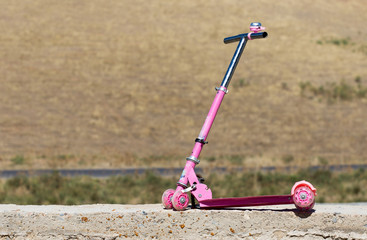 Children's pink scooter in the yard