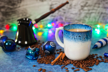 Christmas decorations garland cup of coffee with milk cinnamon sticks scattered coffee beans and black ceramic Cezve