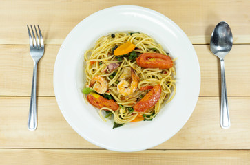 Spaghetti spicy seafood squid in a white dish on wood table,food concept, Close up..