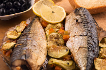 Plate with baked mackerel, zucchini and carrots.