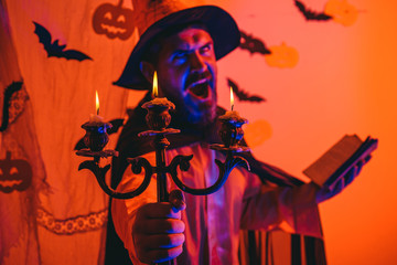 Happy hipster with bloody beard with pumpkins. Scary face man with horror Make up holding Pumpkin...