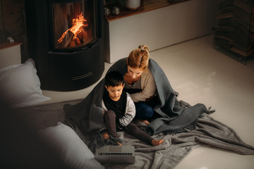 Mother and son watching cartoons on laptop at home