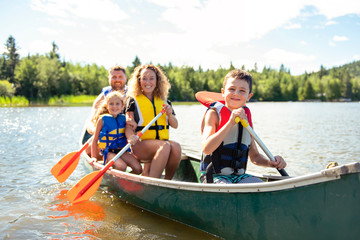 Family in a Canoe on a Lake having fun - obrazy, fototapety, plakaty