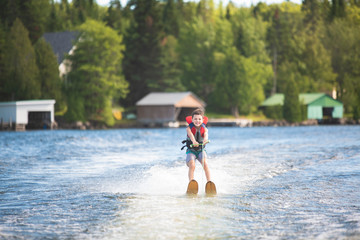 Child learning to water skiing on a lake