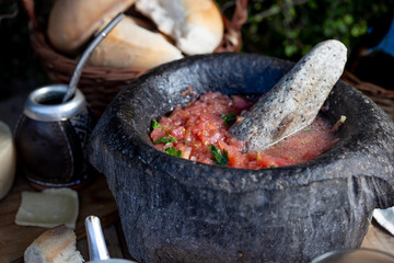 Traditional Latin American mexican Tomato sauce salsa, chilean chancho en piedra in stone mortar.