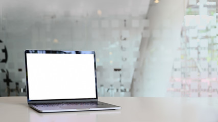 Laptop showing blank with screen on table in office.