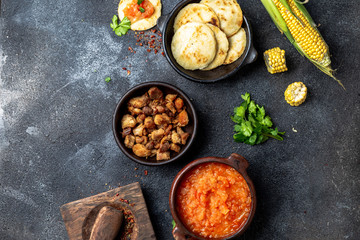 COLOMBIAN traditional food. Chicharron, maize arepas with tomato and onion sauce. Top view