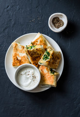 Rolls stuffed with chickpeas, spinach, leek and mozzarella on a dark background, top view. Tasty snack