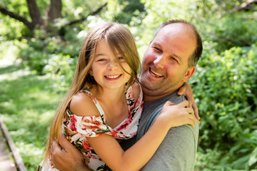 man is playing with his daughter in the nature