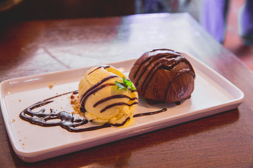 Close Up Still of Scoops of Chocolate and Vanilla Ice Cream with Chocolate