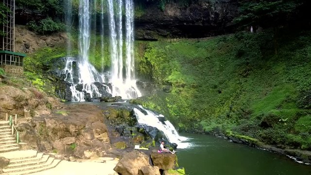 stone steps by brown bare rocks against waterfall