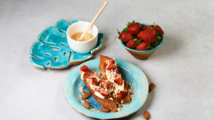 Bruschetta with strawberry, nuts and cheese camembert on gray background. Top side view, close up
