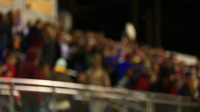 DEFOCUSED CROWD AT FOOTBALL GAME IN STANDS WALKING