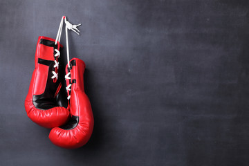 Boxing gloves hanging on a black wall