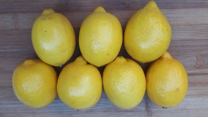 7 citrons jaune sur fond en bois