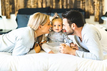 Fototapeta premium Family on bed with his baby on the morning
