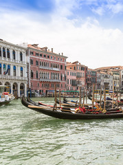 Tourists travel on gondolas at canal Venice, Italy . Gondola trip is the most popular touristic activity in Venice.