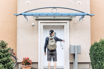 The tourist rings the doorbell to check in to the room he has booked or the student with the...