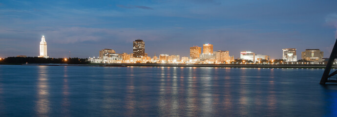 Horizontal composition covering the Mississippi River waterfront and the State Capitol of Louisiana...