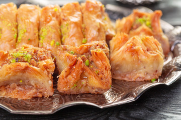 Turkish arabic dessert baklava with honey and nuts on a silver plate