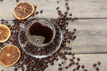 Coffee cup and coffee beans on wooden background.