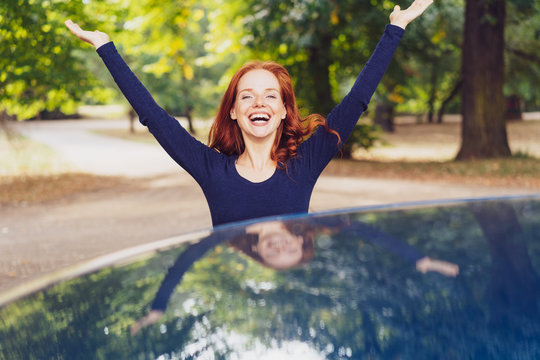 Happy young woman with arms raised in joy