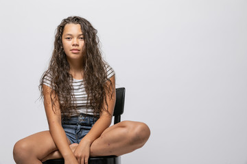 Portrait girl sitting with striped vest isolated
