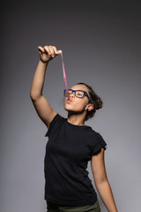 Portrait of teen with glasses in the studio while playing with a chewing gum