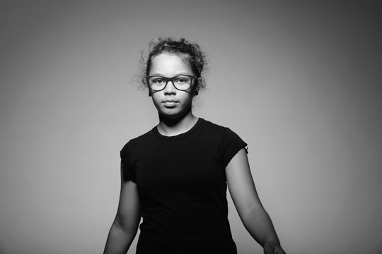 Portrait of teen with glasses in the studio. Black and white image taken in the studio
