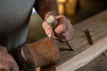 Schreinerhandwerk, arbeiten mit Stemmeisen und Holzhammer am Holzbalken