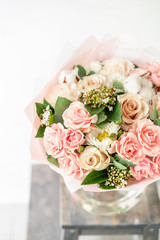 beautiful spring bouquet. flowers arrangement with various of colors in glass vase on old table. bright room