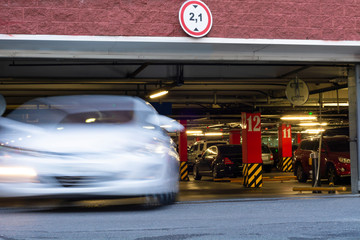 Fototapeta premium Long-exposure photo of car leaving from an underground parking or garage with cars