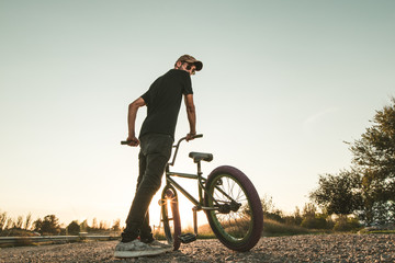 Bmx bike rider in a sunset. Guy riding a bmx bike
